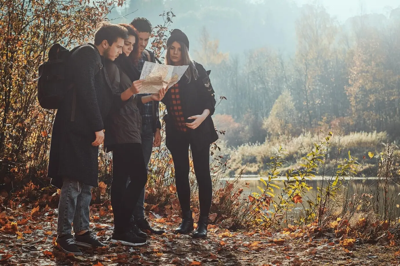 Eine Gruppe von Freunden sucht auf der Karte nach ihrem Standort im Golden Leaf Park.