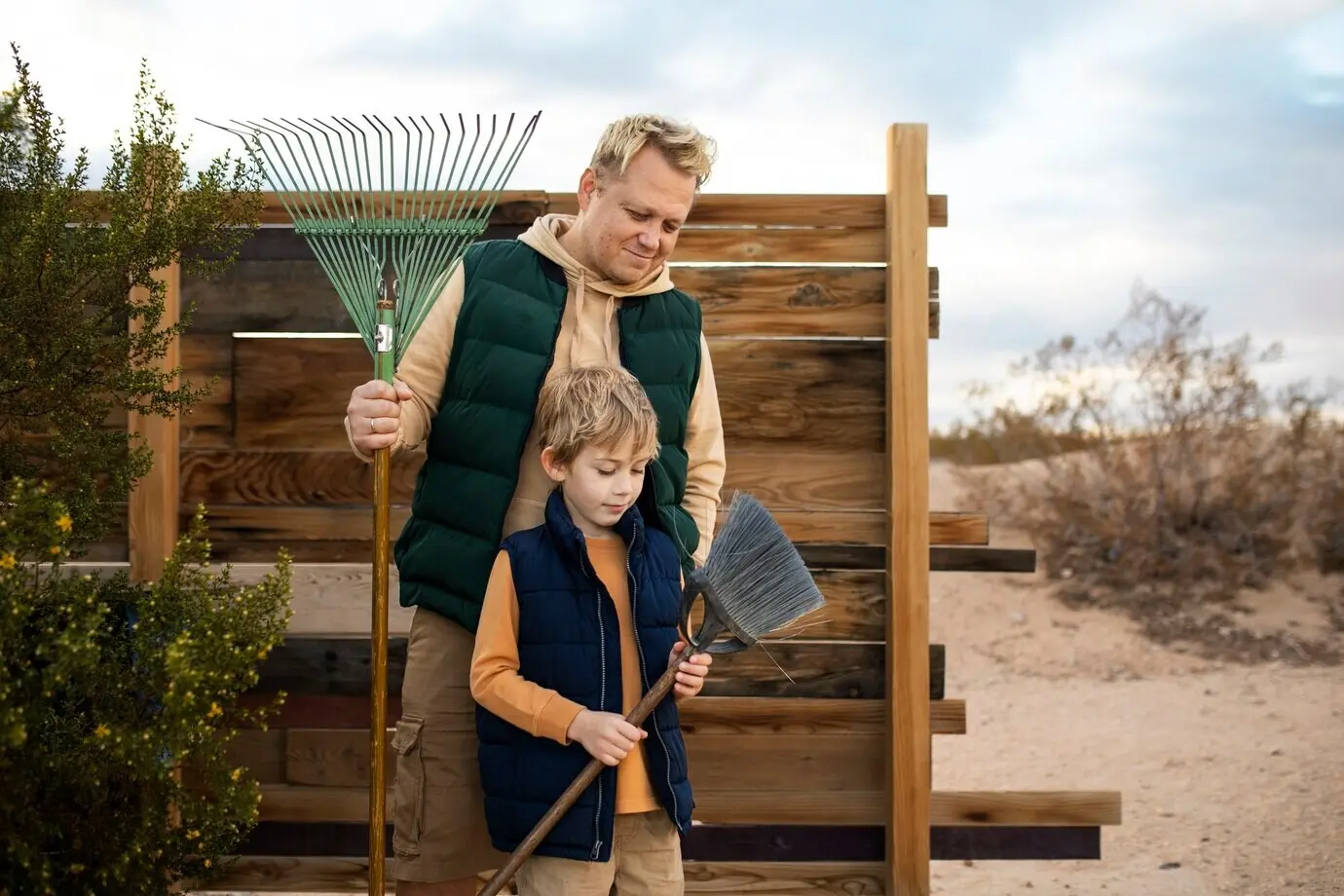 Mittlere Einstellung von Mann und Kind mit Besen.